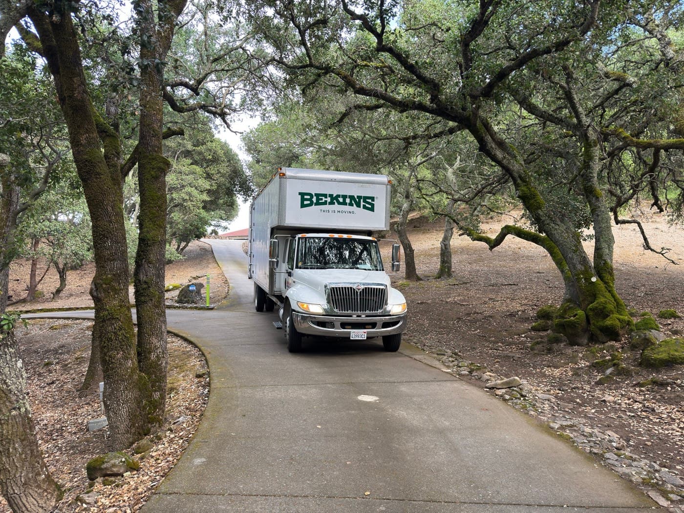 Silicon Valley Moving Bekins truck on a tree-lined Bay Area residential driveway